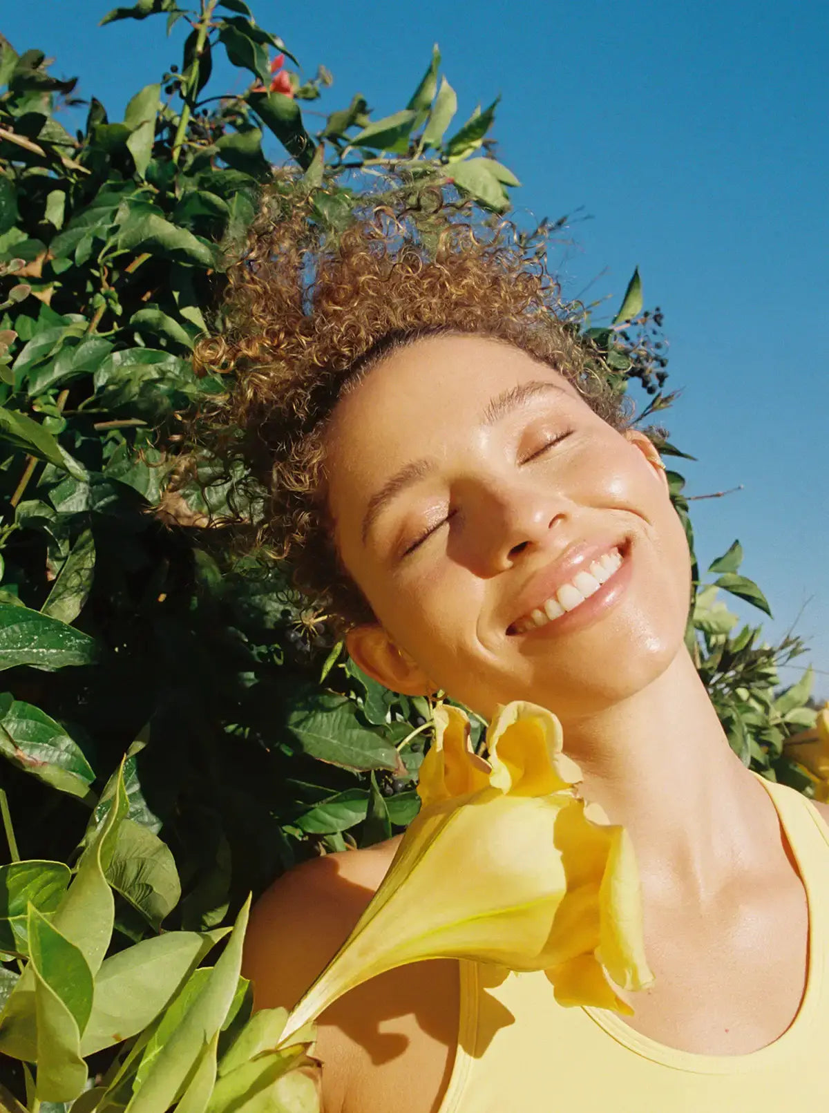 woman smiling in sun after applying summer skincare routine