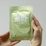 removing the single use soothing aloe vera face mask from its packaging